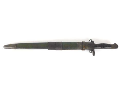 A 1917 Remmington First World War bayonet with part leather scabbard, stamp marks to the blade either side, working push butt