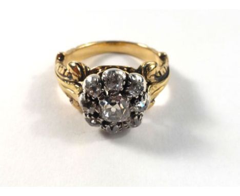 A Georgian yellow gold ring set nine old cut diamonds in a flowerhead setting within an enamel decorated fleur de lis carved 