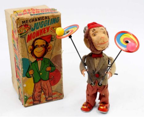 An Alps Toys of Japan tinplate and mechanical model of a Juggling Monkey comprising of soft covered monkey wearing grey coat,