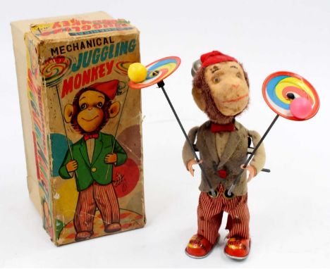 An Alps Toys of Japan tinplate and mechanical model of a Juggling Monkey comprising of soft covered monkey wearing grey coat,