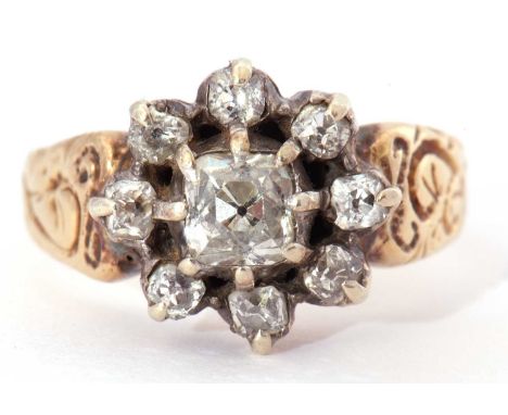 Diamond cluster ring centering an old cushion cut diamond surrounded by seven small old cut diamonds by a further seven small