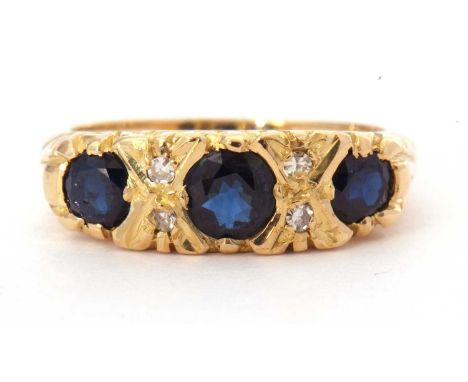 18ct gold sapphire and diamond ring featuring three graduated round cut faceted sapphires highlighted between with four small