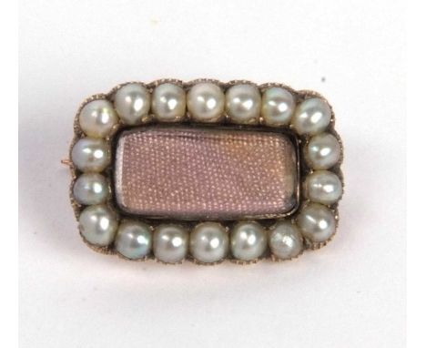 Antique mourning brooch, the vacant glazed central panel set within a small seed pearl surround, 18x12mm overall (a/f)