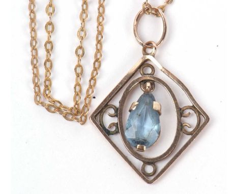 Open work pendant suspending a pear shaped blue stone dropper suspended from a 375 stamped chain