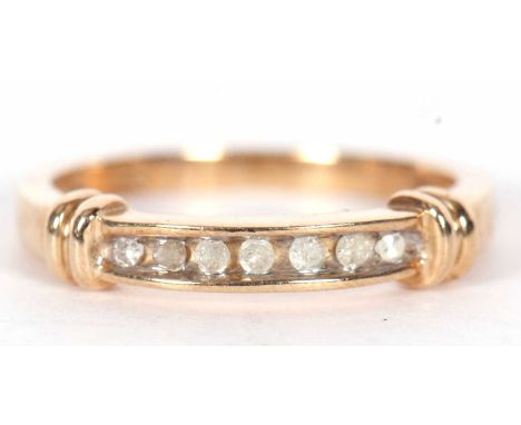 A modern 10K stamped, seven-stone diamond ring, Chanel set with seven round mixed cut diamonds total ct weight 0.08cts finger