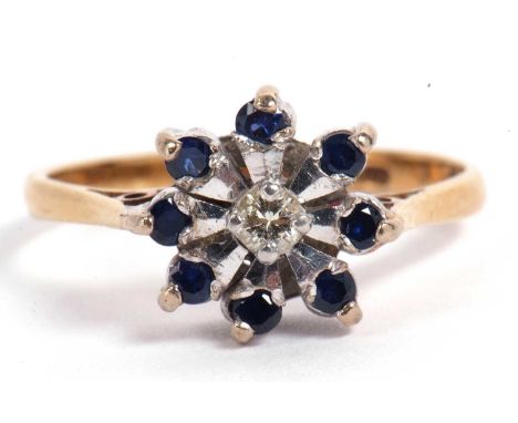 Sapphire and diamond flower head ring centering a small brilliant cut diamond surrounded by eight small sapphire tipped petal