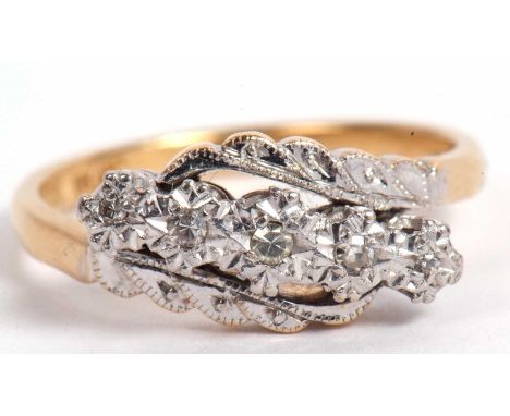 Diamond crossover ring featuring five small graduated diamonds each individually in illusion settings raised between carved c