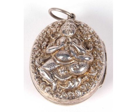 Large vintage Indian white metal locket of oval form, twin sided and embossed and chased with deities, hinge opening to a gla