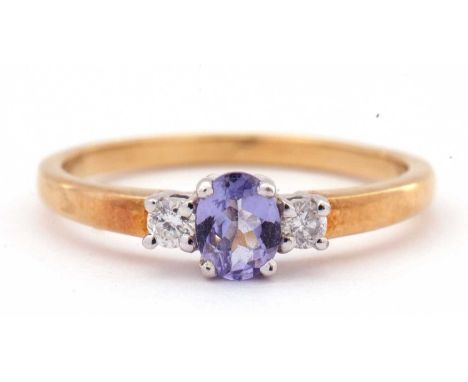 Tanzanite and diamond three stone ring, the oval cut tanzanite is 5x4mm raised between two small brilliant cut diamonds, stam