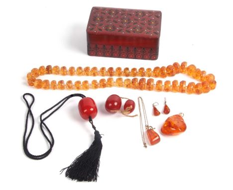 Mixed Lot:  Vintage cherry amber large drum shaped bead on a black chord necklace, two loose graduated cherry amber beads, a 