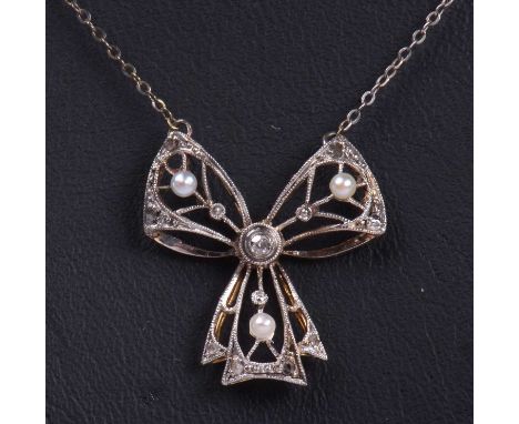 Diamond and seed pearl set bow pendant decorated with small graduated old cut diamonds and highlighted with three small seed 