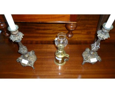 A pair of reproduction Victorian style candle holders and a brass oil lamp.