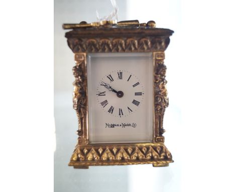 A Mappin & Webb brass cased miniature carriage clock, each corner modeled with a relief moulded lady 