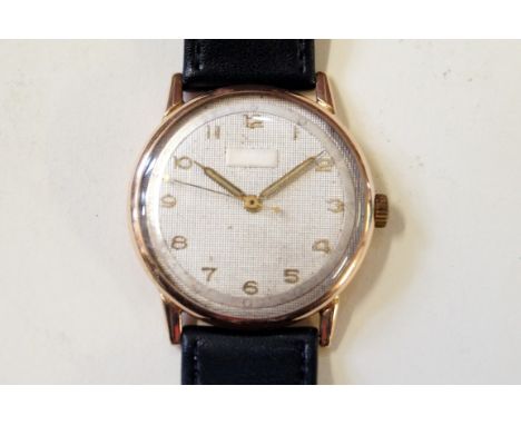 A gold manual wind wrist watchTo a black strap