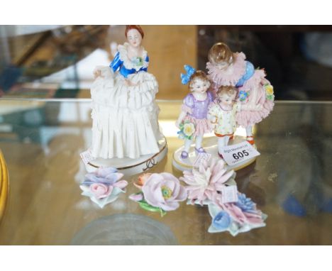 A continental porcelain figure group of a woman with two children further continental figure group and four ceramic flower mo