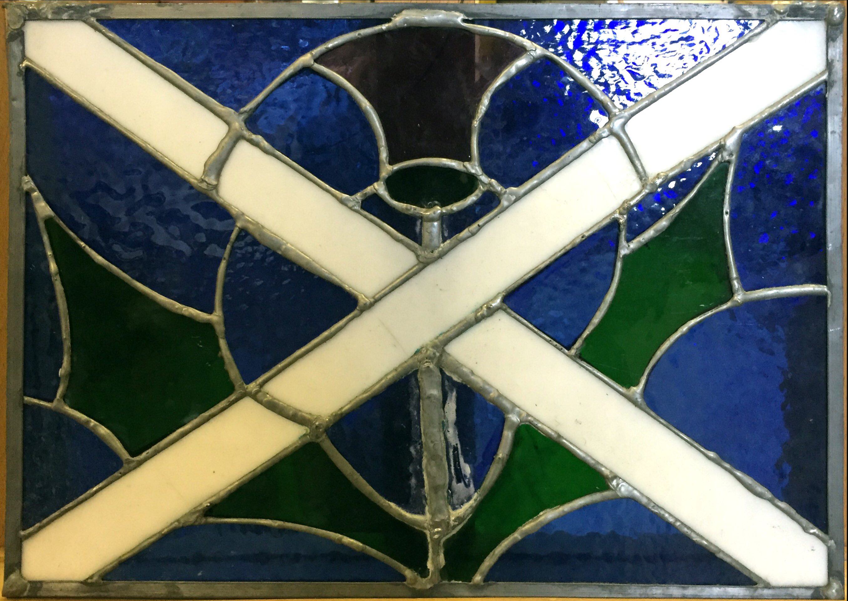 A stained glass panel of The Scottish flag and thistle. H 294mm W406mm