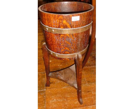 A brass bound oak planter on tripod legs by Lister &amp; Co of Dursley