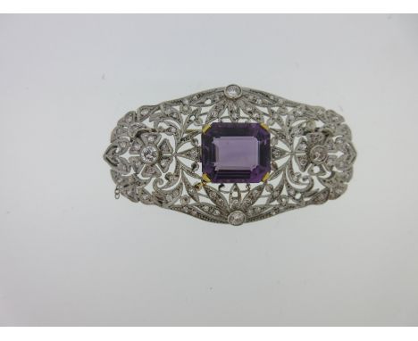the octagon cut amethyst, measuring 15.4 x 13.5mm, estimated weight approximately 12cts, four claw set in a pierced plaque of