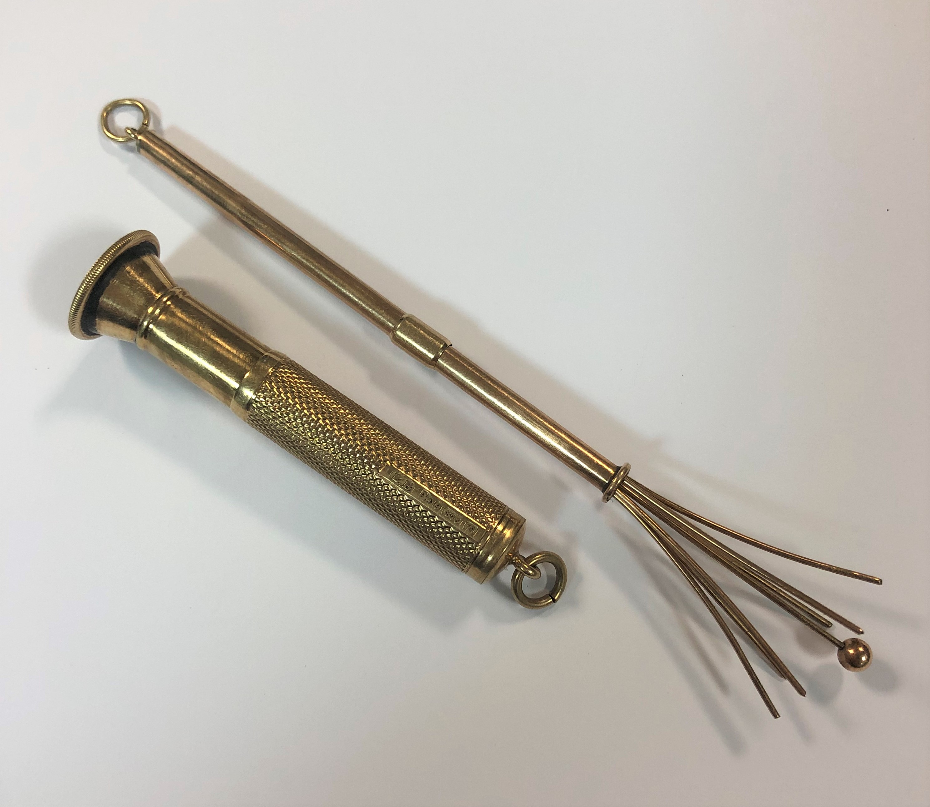 A 9ct gold swizzle stick and a 9ct gold cigar piercer Barnebys