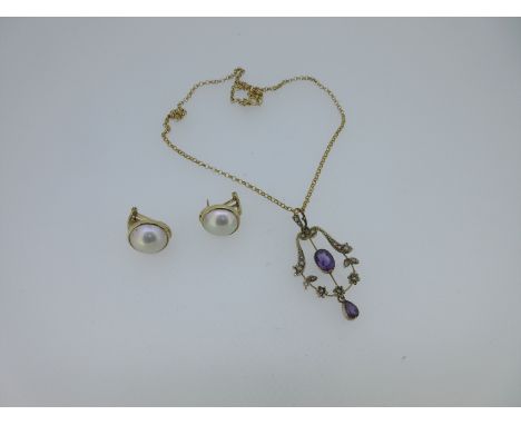 the open garland style pendant set around with tiny seed pearls and a knife edge bar down the centre holding an oval cut amet