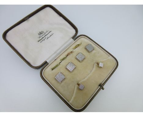each of the four buttons and two collar studs a cut corner square with engine turned white on polished and textured yellow me
