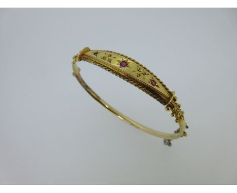 the front with a curved navette panel gypsy set with three round cut rubies, and with pointed trefoils between, each set with