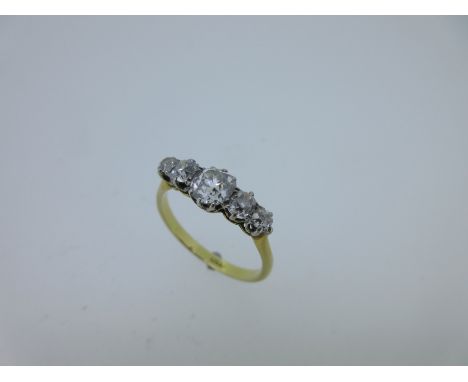 the graduated old cushion cut diamonds claw set to a coronet gallery, tapered shank size R, white on yellow metal stamped '18