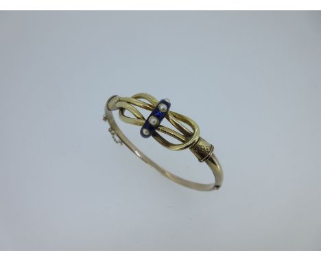 the front designed as an open reef knot with a royal blue guilloche enamel band across the centre set with four seed pearls, 