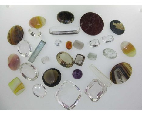 to include an aquamarine rough crystal weighing 46cts, a quantity of faceted polished stones of various shapes, including a r