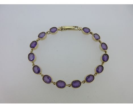 the line of fourteen uniform oval cut amethysts deep collet set with chain connections, two stage ladder clasp, Birmingham ha