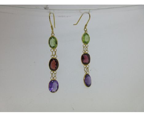 each hook suspending a line of three oval cut spectacle set stones, one each of peridot, garnet and amethyst, fine wire doubl