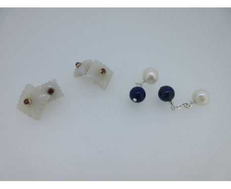 the first with a small ruby cabochon in the centre of a stylised square flower of white chalcedony, with carved radiating lin