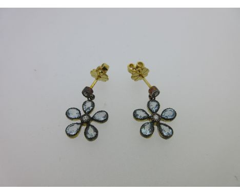 each post headed by a small round brilliant cut diamond and suspending a flower, with similar diamond centre and five spaced 