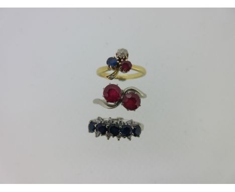 the first a ruby two stone crossover ring, with round cut rubies claw set to coronet galleries, the shank forming a serpentin