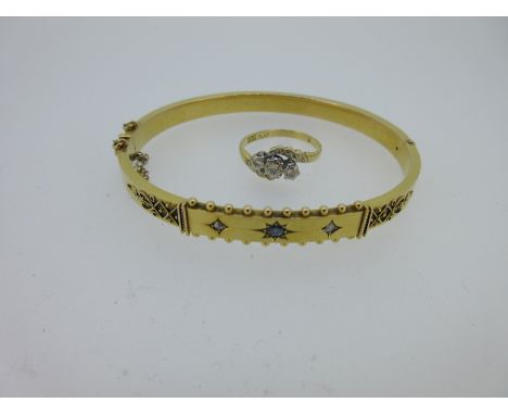 the bangle with a bead-edged panel to the front gypsy set with a round cut sapphire and two diamonds, shoulders with applied 