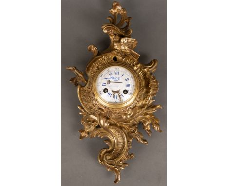 Carteluhr. Frankreich 19. Jh. Vergoldete Bronze, rocaillereliefiert, oberhalb durchbrochen, rundes Emailleziffernblatt mit do