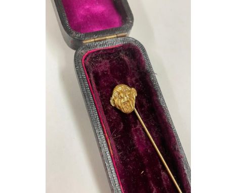 A yellow metal funny face stick pin