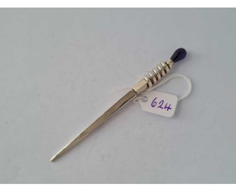 A unusual silver cocktail stick with purple stone