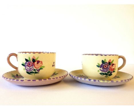 A pair of Carter Stabler Adams Limited red bodied Poole Pottery cups and saucers, decorated in the WW pattern.