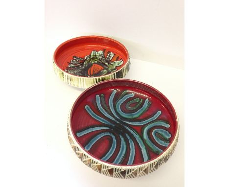 A large Poole Pottery carved fruit bowl, shape 89, decorated in an abstract pattern on red ground by Angela Wyburgh together 