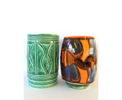 A small cylindrical Poole Pottery carved vase, decorated in a Fish design in tones of green together with a Delphis vase, dec