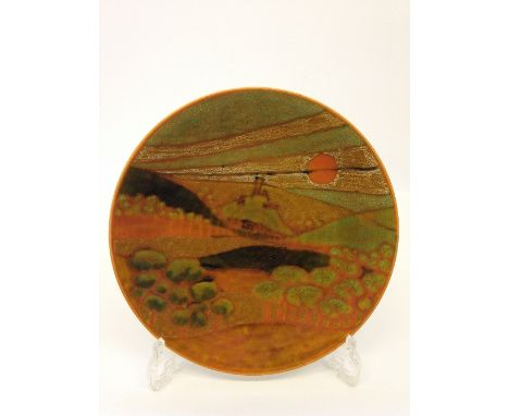 A Poole Pottery Studio dish, shape 4, decorated with a stylised view of Corfe Castle under a red sky on magnolia ground (10.5