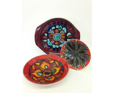 A Poole Pottery Delphis bowl, shape 57, decorated in an abstract pattern on red ground together with a serving platter and a 