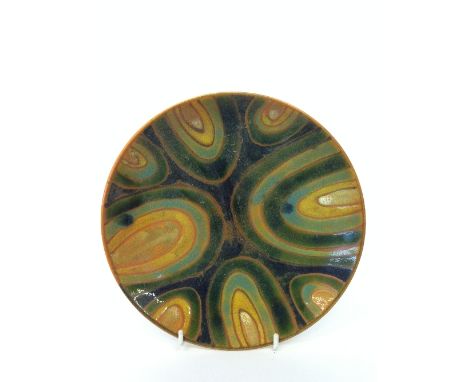 A Poole Pottery Studio dish decorated in an abstract pattern in tones of green, blue and yellow on magnolia ground (Mark No. 