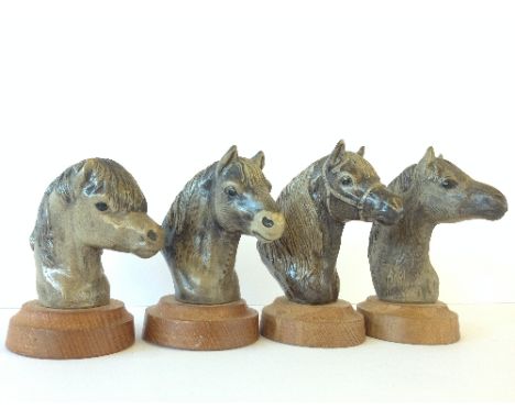 A Poole Pottery Barbara Linley Adams set of four stoneware models of Pony Heads, mounted on circular wooden bases: New Forest