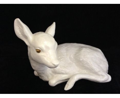 A Poole Pottery white bone china model of a large fawn with gold painted eyes.