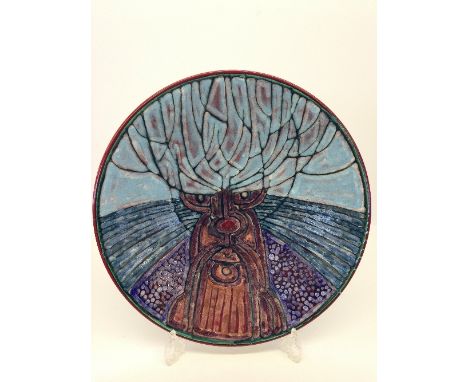 A modern Poole Pottery Studio charger by Tony Morris decorated with a pollarded tree in tones of blue, purple and brown (pain
