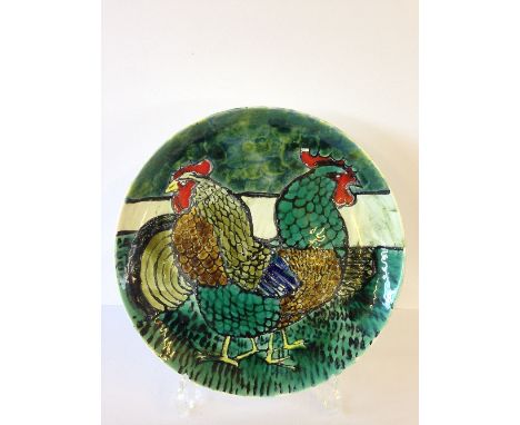 A Poole Pottery Studio dish, decorated in bright colours with two cockerels in the style of Robert Jefferson in tones of gree