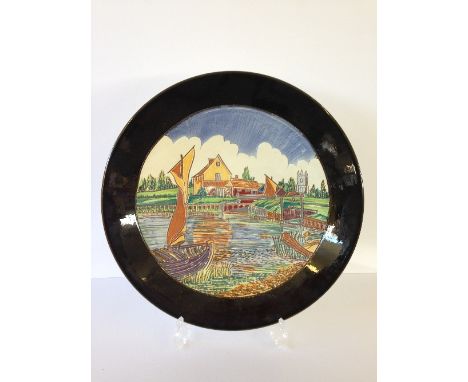 A Poole Pottery dish, shape 54, decorated in a carved Landscape design by Leslie Elsden: River Scene.