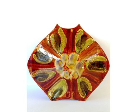 A Poole Pottery "Packet of Crisps" shaped vase, decorated in a floral abstract pattern in tones of green, brown and blue by J